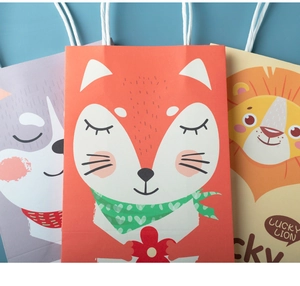 Detail of cute animal paper gift bags with colorful fox and lion prints and rope handles