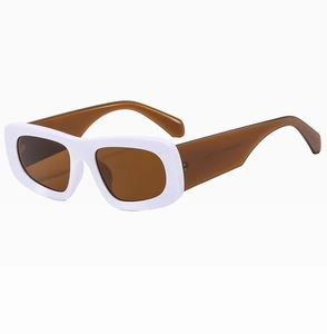 Detail view of bold white rectangular frame sunglasses with brown translucent lenses