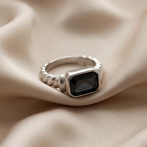 Macro detail of twisted silver band with large emerald-cut black stone inlay