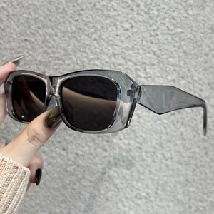 Detailed view of translucent grey polygon frames and dark tinted lenses of retro sunglasses