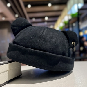 Detail of black cat ear beanie with metal ring decor and premium cotton texture