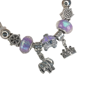 Silver beaded bracelet with purple glass charms, crown, elephant and carriage pendants