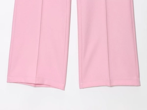 Dettaglio ravvicinato dell'orlo svasato e delle cuciture dei pantaloni rosa a zampa