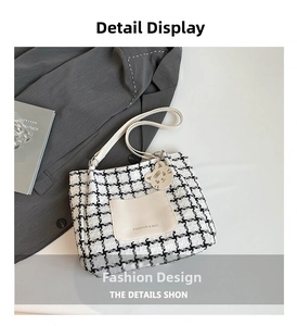 Close-up of contrast houndstooth tote bag with leather pocket and cute cat pendant