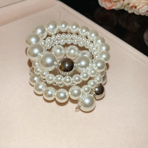 Detailed macro of multi-layered pearl bracelet with silver beads in a pink jewelry box