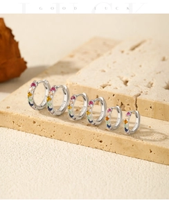Macro detail showing three pairs of S925 sterling silver rainbow hoop earrings with crystals