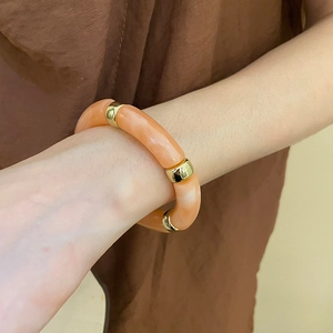 Detail of pink marble acrylic beaded bracelet with golden ring spacers on wrist