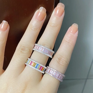 Detailed view of rainbow and pink zircon eternity bands worn on a hand model