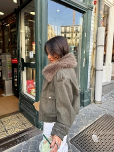 Detail view of women's dark grey winter jacket with fluffy brown faux fur collar