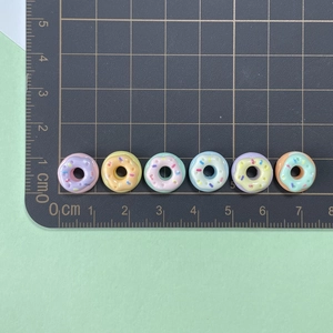 Macro detail of 1.5cm mini resin donuts with sprinkles for DIY craft and nail art