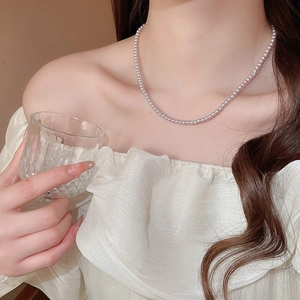 Detailed view of elegant pink pearl beaded necklace worn on neck with minimalist design