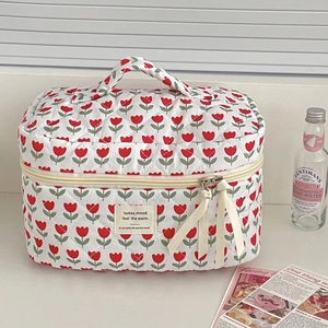 Dettaglio della borsa trapuntata con tulipani rossi e zip decorata con nastro elegante