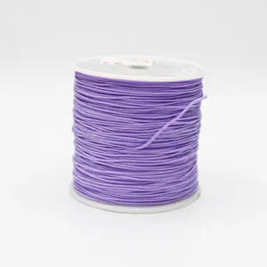 Detailed close-up of 0.8mm purple braided cord wrapped on a spool for jewelry making