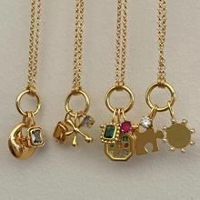 Détail de pendentifs en acier inoxydable plaqué or 18K aux motifs célestes et gemmes