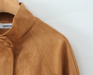 Detail view of brown suede jacket showing the stand collar and high-quality shoulder texture