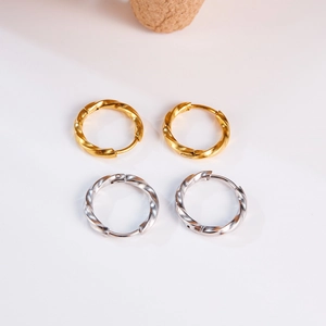 Detailed macro view of gold and silver Mobius twisted metal hoop earrings