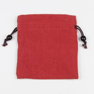 Dettaglio di un sacchetto per gioielli rosso in lino con coulisse e perline in legno