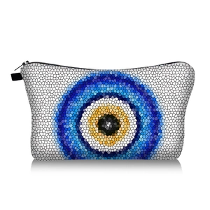 Close-up of portable evil eye makeup bag with blue mosaic pattern and black zipper handle