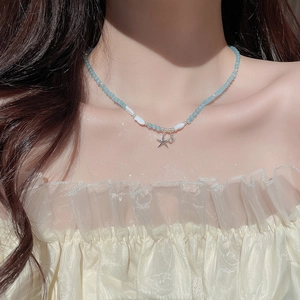Détail du collier de perles avec pendentif étoile de mer et petites perles de poisson