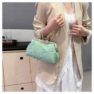 Detailed shot of a mint green mesh shell bag with 3D floral patches and chain strap
