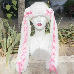 Detail of white crochet bunny ear balaclava with pink ribbon lace-up and bow accents