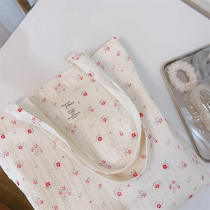 Detail of floral cotton tote bag featuring lace texture and vintage brand label tag