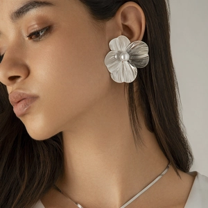 Elegant silver ginkgo flower stud earrings with pearl center worn by a model