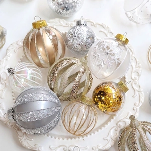 Champagne Christmas ball ornaments set with glitter and snowflakes on a white plate