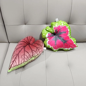 Detail of leaf-shaped plush pillows with Caladium leaf vein patterns on a modern sofa