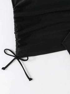 Close-up of black swimwear fabric featuring ruched side drawstring and tied bow detail