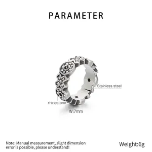 Detailed view of vintage stainless steel XO ring with crystal stones on white background