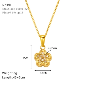 Macro detail of gold flower pendant with zircon inlay on a 18k plated chain