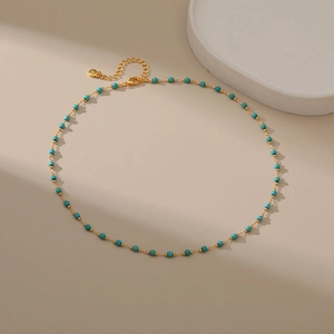 Detail of 18K gold plated necklace featuring turquoise beads and lobster clasp closure