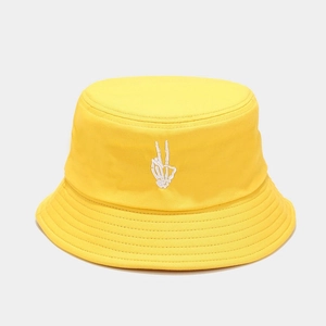Close-up of skeleton hand embroidery on a vibrant yellow cotton canvas bucket hat