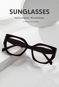 Detail einer schwarzen polygonalen Sonnenbrille mit rosa Gläsern und Code am Bügel