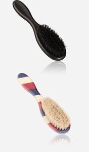 Detail view of two professional barber neck brushes with black and striped handles