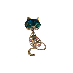 Fashionable gold cat brooch with sparkling colorful crystals on a white background