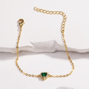 Détail du bracelet cœur vert émeraude avec une chaîne ajustable dorée et zircons