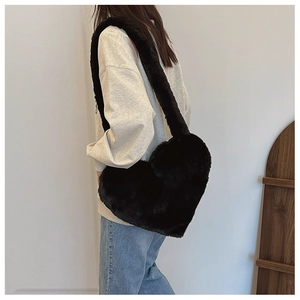 Macro detail of a heart-shaped black faux fur shoulder bag with soft plush texture