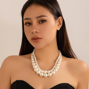 Detail of double-layer faux pearl necklace with heart pendant on model for elegant look