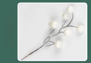 Detailed view of handmade white pearl berry stem with silver textured branches for decor