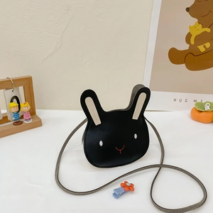 Detail of cute black bunny-shaped kids crossbody bag with white ears and gray strap