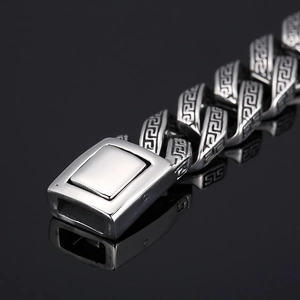 Macro shot of silver stainless steel skull bracelet clasp with greek key pattern details