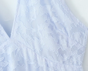 Detail of light blue lace halter dress with floral texture and plunging V-neck design