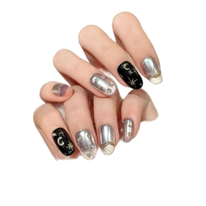 Black and silver oval press-on nails featuring golden star and moon motifs with rhinestones