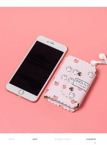 Détail d'un porte-cartes en cuir rose avec motifs lapin pêche et bords ondulés