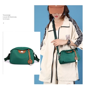 Dettaglio della borsa a tracolla in nylon verde con patta in pelle marrone e decori in metallo