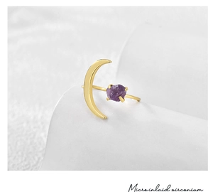 Macro detail of gold moon ring featuring a raw purple stone and micro-inlaid zirconium