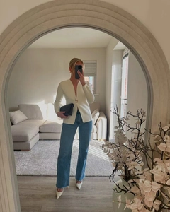 Spiegelselfie eines weißen Blazers mit tiefem V-Ausschnitt, Jeans und weißen High Heels
