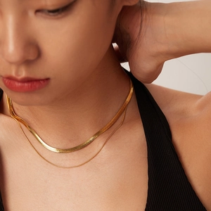 Gros plan sur le collier double couche plaqué or 18 carats avec chaînes serpent et rondes